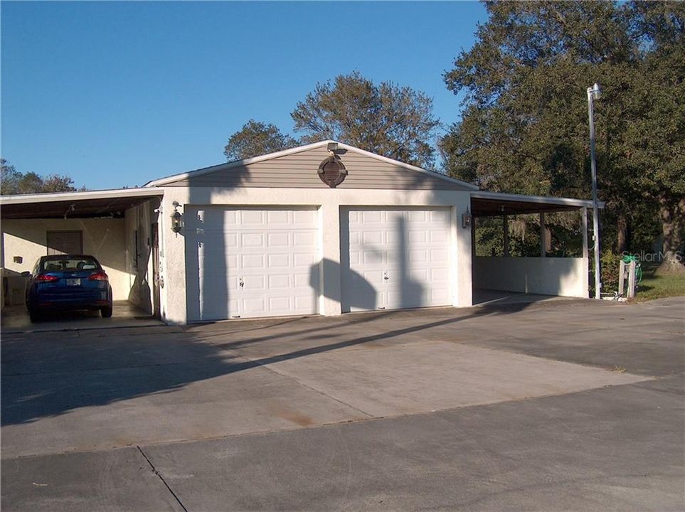 2 Car Garage with a carport on each side.  This garage has a separate huge workshop in the rear and it has AC!!Ample parking for boats, RV's, and toys!!