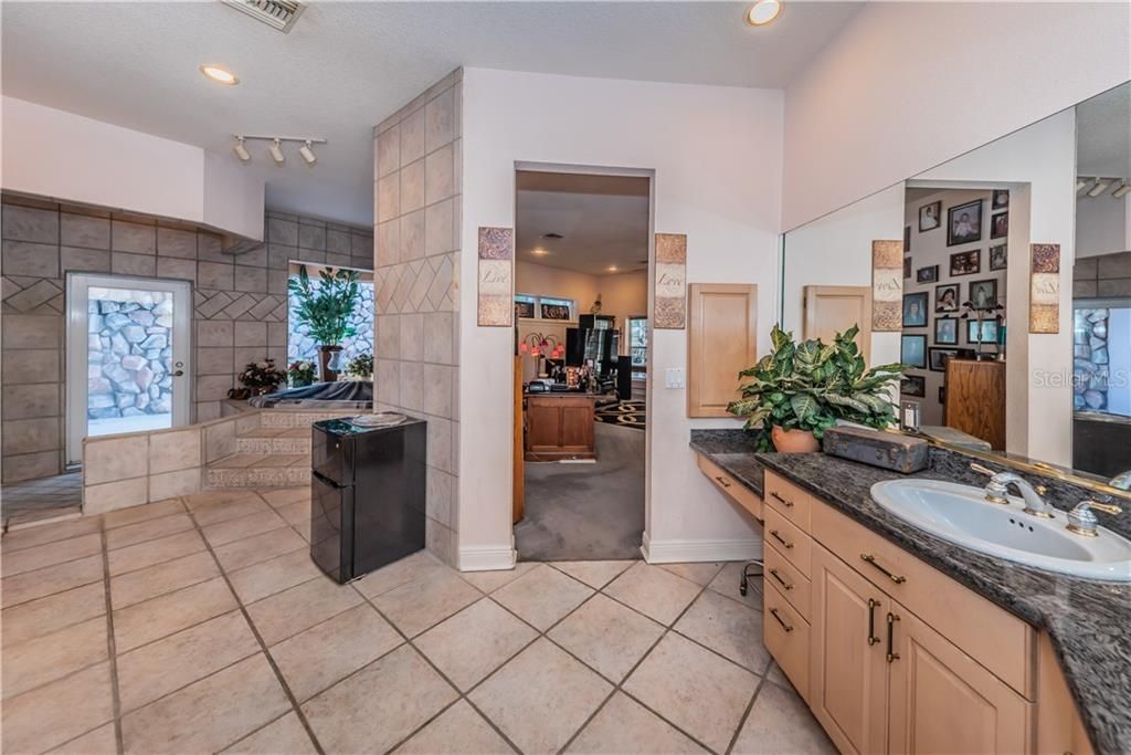 HUGE MASTER BATH WITH DUAL SINKS, WALK IN SHOWER, GRANITE COUNTERS, WOOD CABINETS AND FULL SIZED JETTED SPA AND EXIT TO A PRIVATE OUTDOOR COURTYARD.