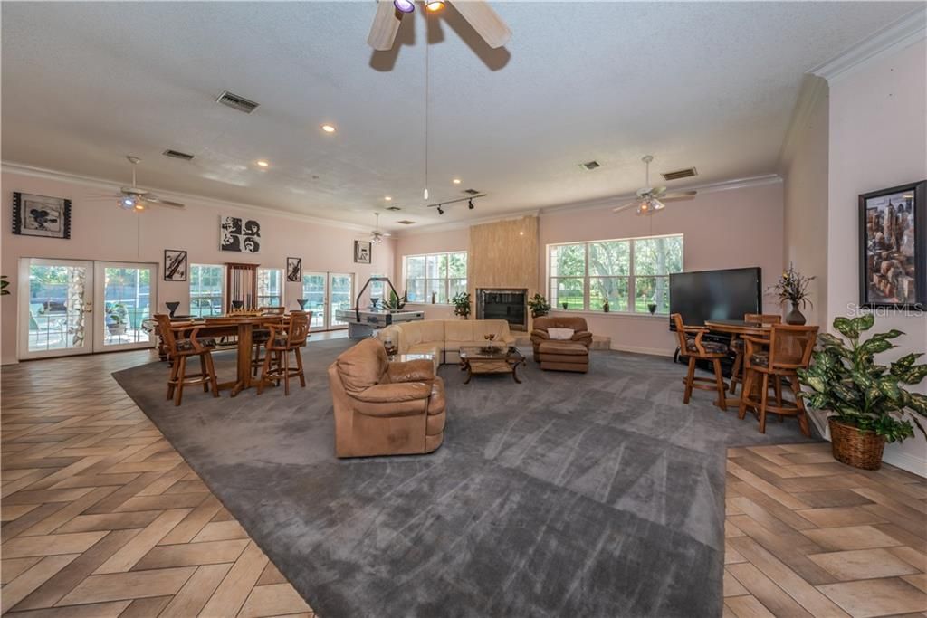 STUNNING GREAT ROOM/ FAMILYROOM WITH HIGH CEILINGS, WOOD BURNING FIREPLACE, WET BAR AND VIEWS OF POOL AND LANAI AND REAR VIEWS OF THIS GORGEOUS PROPERTY