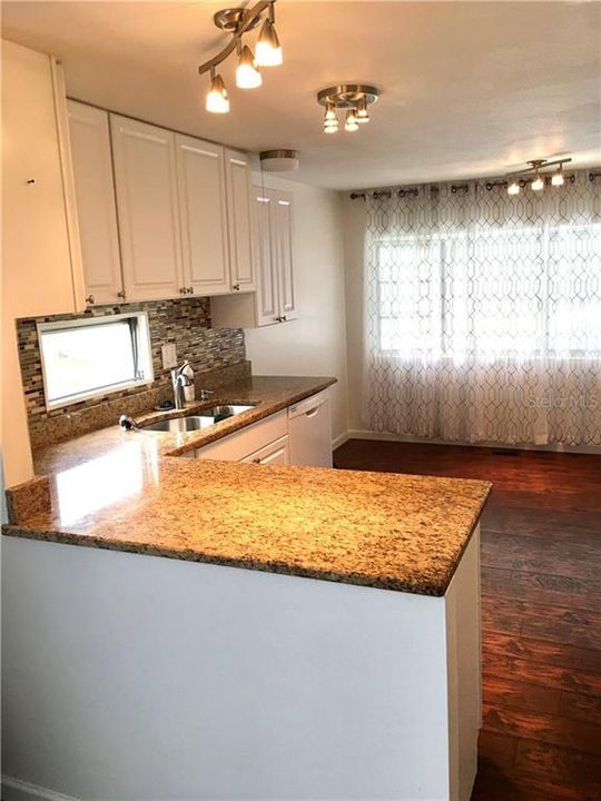 new granite fixture and cabinets in kitchen.  wonderful natural lighting in the eating area