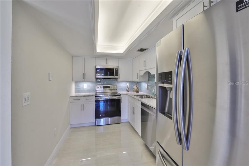 Updated kitchen with white shaker cabinets.  Smartly designed with plenty of storage and counterspace