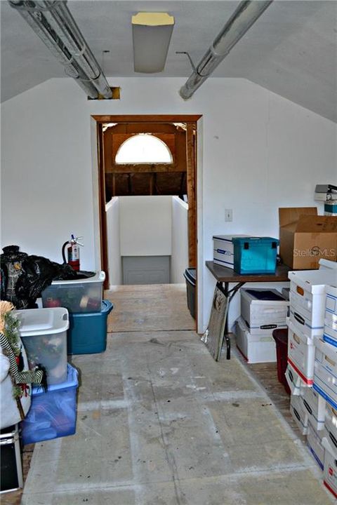 Huge storage spaces in attic extend beyond the doorway.