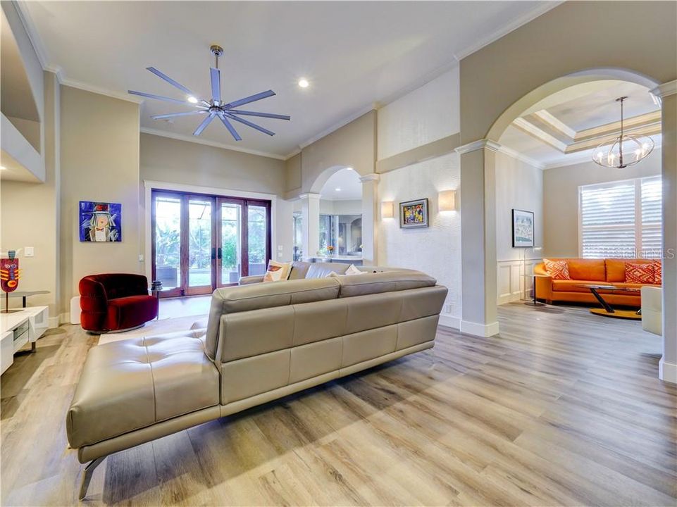 Living room, adjacent arched entry into the formal Dining room which is being used as family room/den