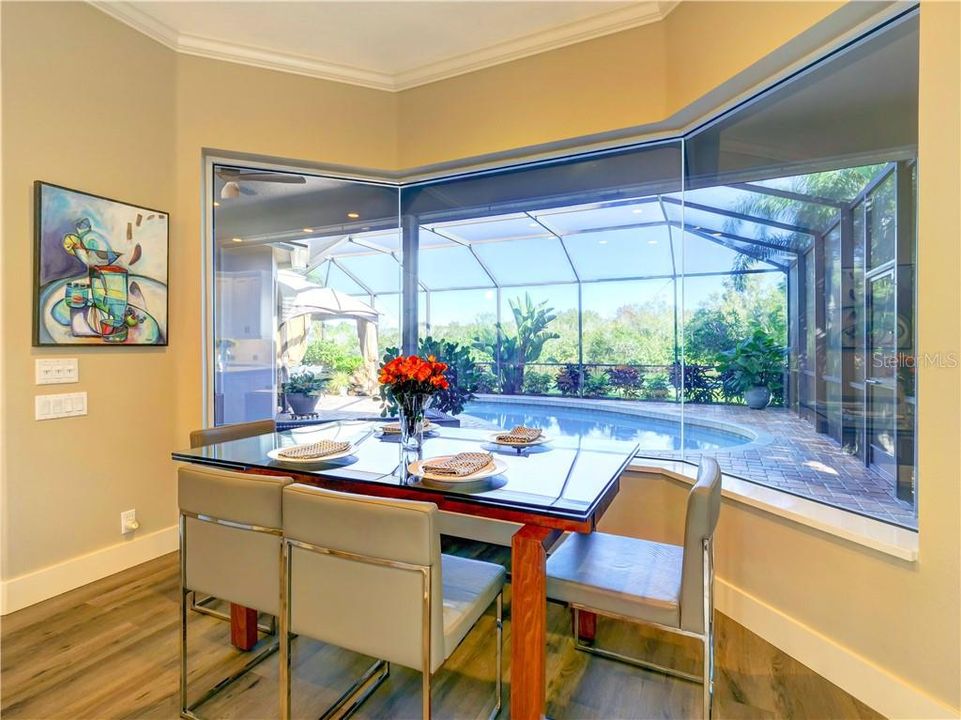 Eating space adjacent to the kitchen, aquarium glass over looking patio and pool