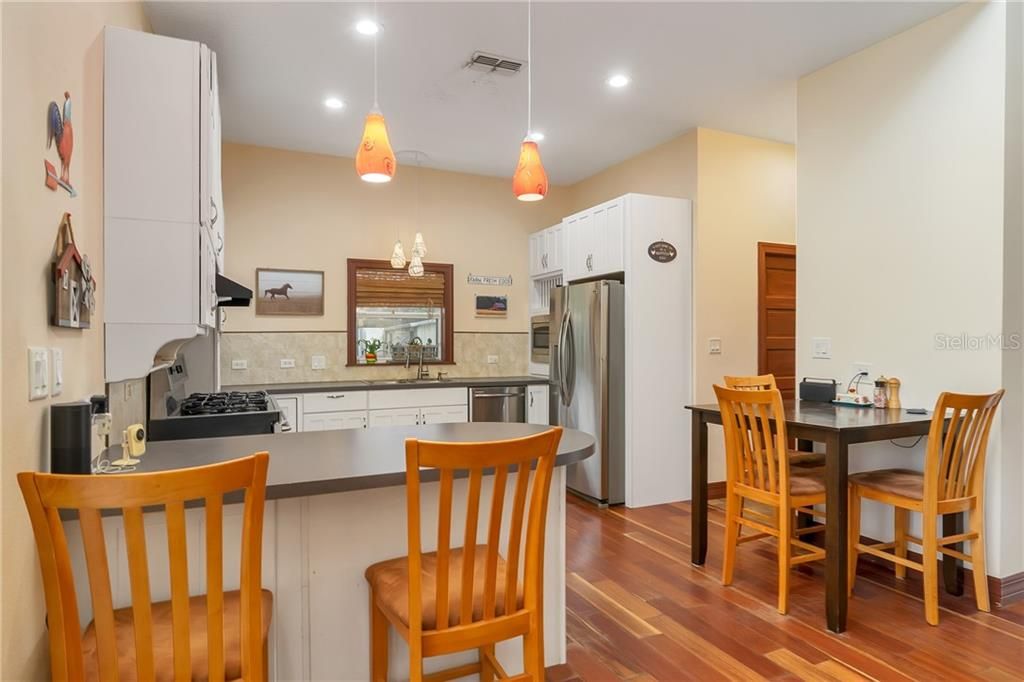 Nice bright kitchen with White cabinets and extra counter space. Brazilian cherry floors continue. High ceilings makes this a beautiful place to begin and end the day