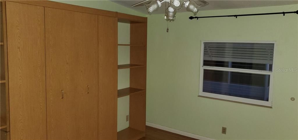 2nd bedroom has Murphy bed/book case allowing room to be used for office or hobbies and fold bed down for guests when needed.  Fan/light and walk in closet. Hardwood floor.