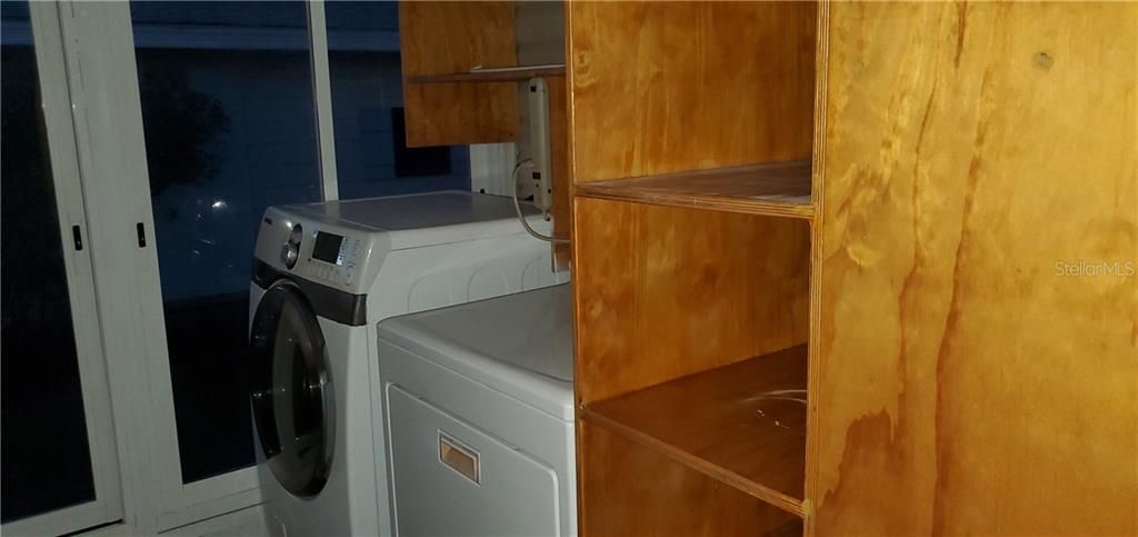 Laundry room with front loading washer and dryer.  Lots of storage shelves in this room