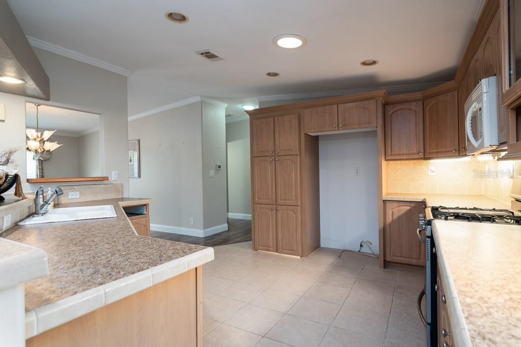 Kitchen towards huge walk-in pantry. Recessed lighting and solar tubes provide an abundance of natural lighting.