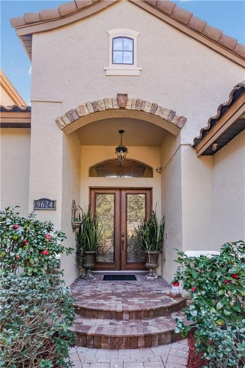 Lovely entrance with designer pavers and leaded glass double front doors.
