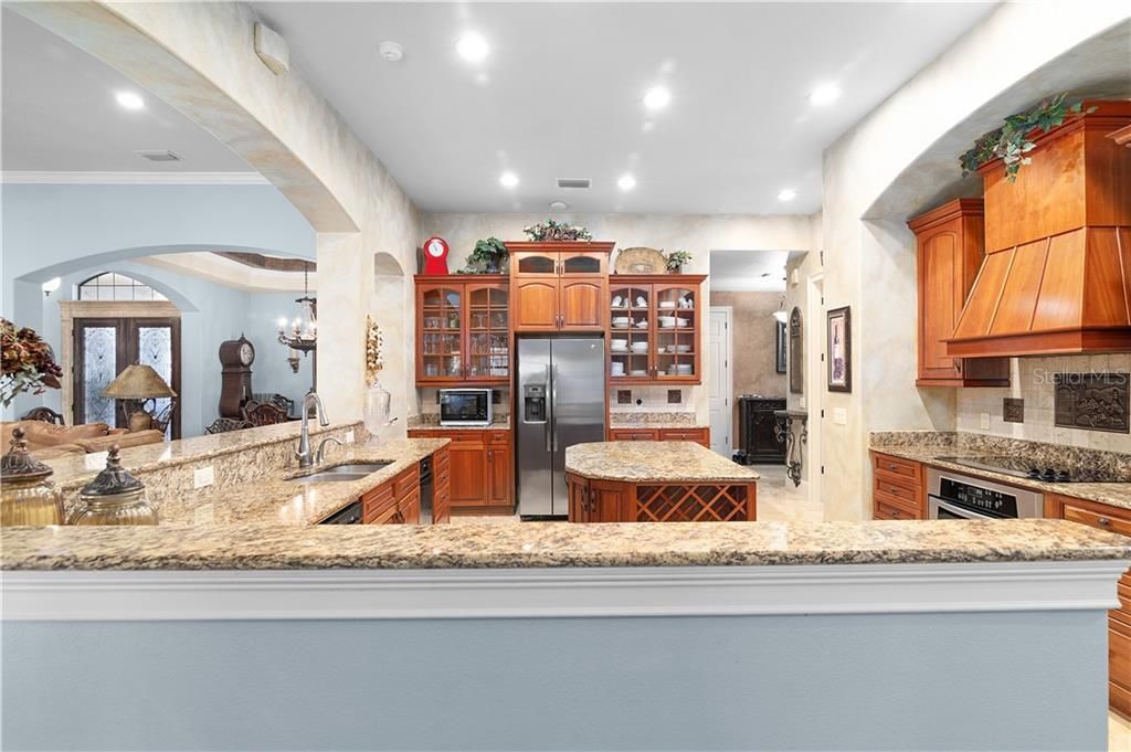 Gourmet kitchen with two ovens, large island with wine rack, 42" custom cabinets and pantry.