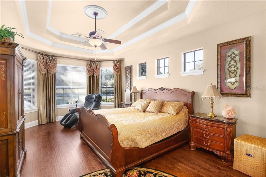 Lovely master bedroom with views of both the pond and pool.