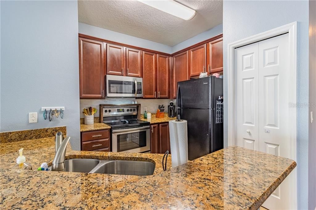 Kitchen includes granite, modern tile backsplash and closet pantry.