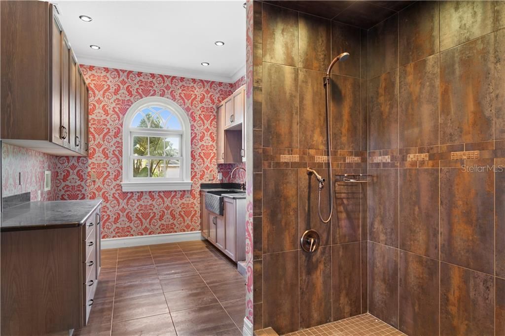 The laundry room has a full size shower and plenty of drawers and cabinets for storage