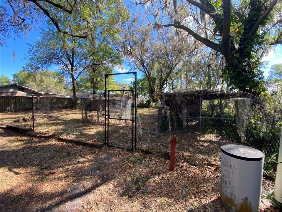Fenced area in backyard with 2 Chicken Pens