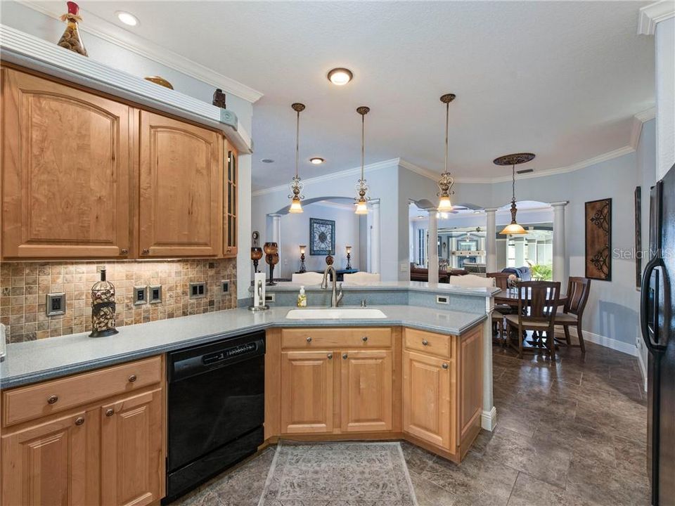 Fabulous Kitchen with a Fabulous Breakfast Nook encased in columns. Perfect view through the Breakfast Nook and into the Great Room and out to your very own Tropical Oasis.
