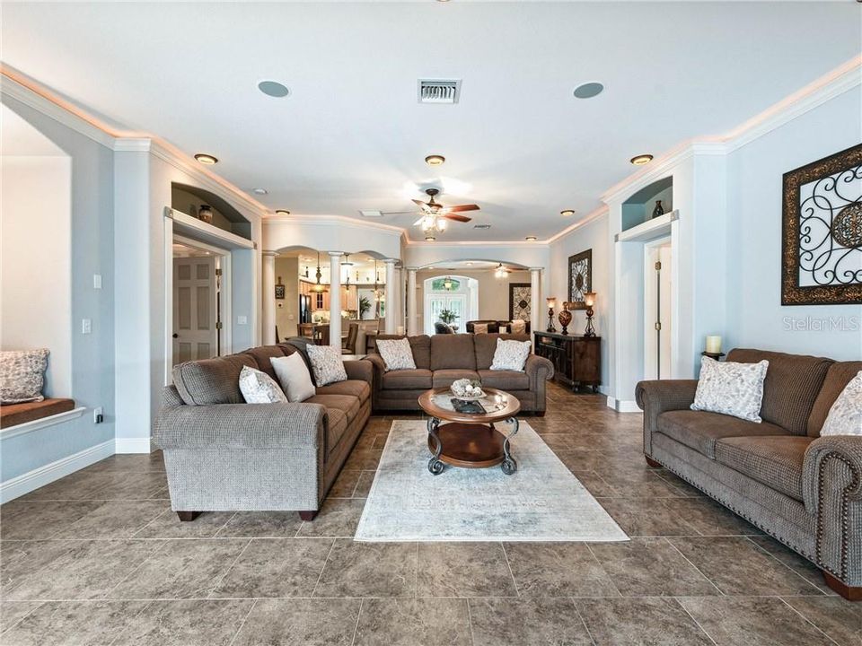 View of the Great Room from the outside Covered Lanai where the 18' sliding glass doors pocket into the wall behind the decorative columns. The window seat with storage is to the left and the door to the right in the super spacious Laundry Room.