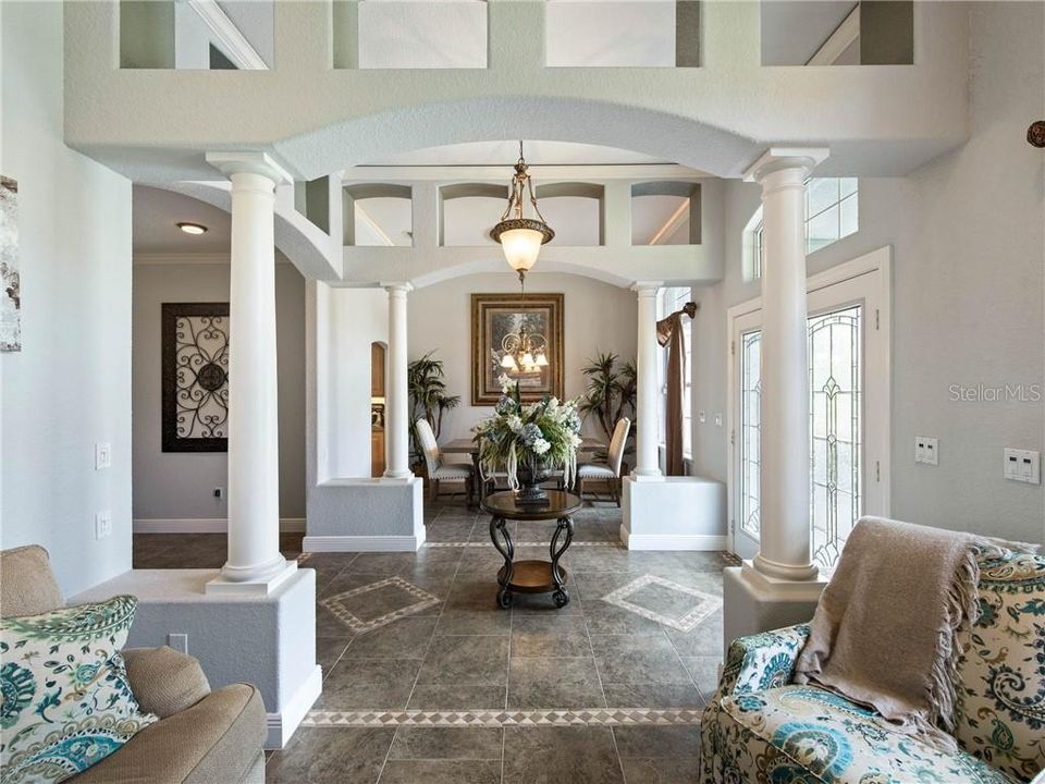 View of the Entry and Formal Dining Room from the Formal Living Room. Beautiful Architectural details with crown molding and ambient lighting .