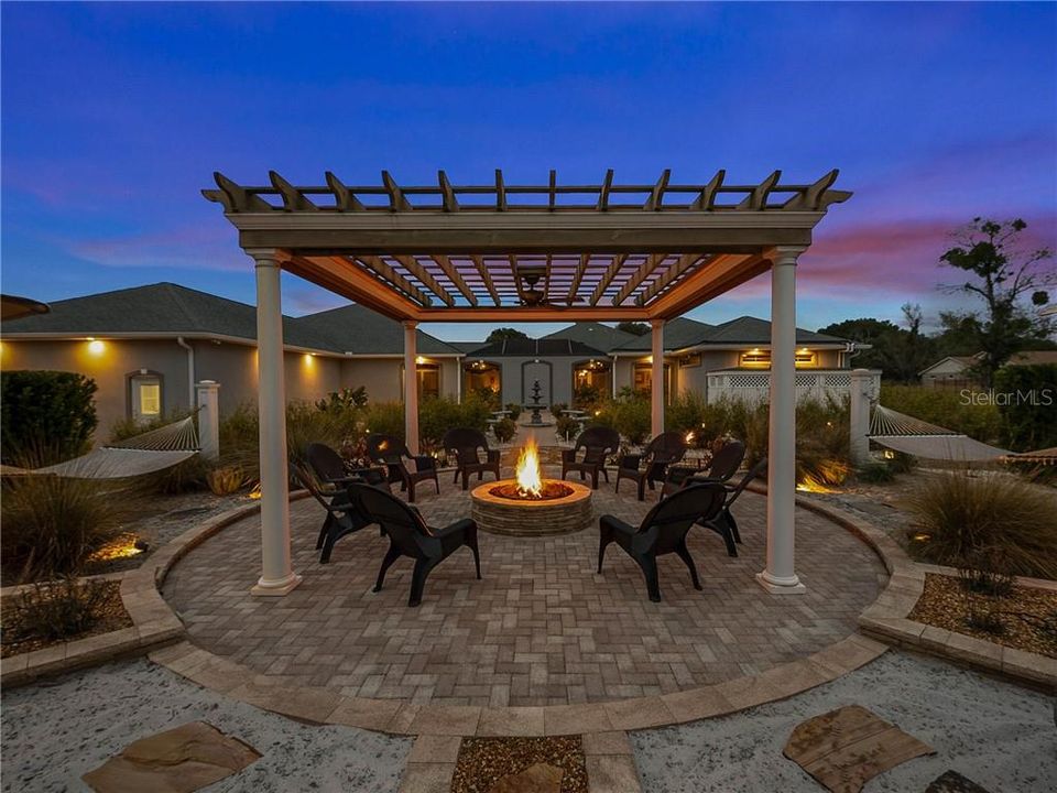 Relax by the fire and enjoy the beautiful sunsets! This backyard wonderland has two double hammocks and plenty of seating for your family and friends. The lighting dances all around this space, from the crown molding with ambient rope lighting, landscape lighting, to the recess lights in the soffits around the home.