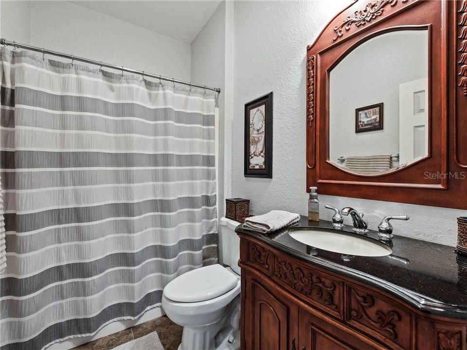 Jack & Jill Bathroom with tub/shower combination, custom vanity furniture with granite countertops, undermount sink, 8" widespread faucet with matching mirror, medicine cabinet and linen closet behind the door.