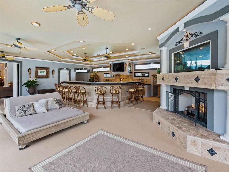 Outdoor Hibachi Kitchen with elaborate details from the decorative tray ceilings with crown molding and ambient rope lighting, recess cans, transom windows, sliding glass doors leading into the state-of-the art Billiard and Game Room on the other side of the fireplace built-in.