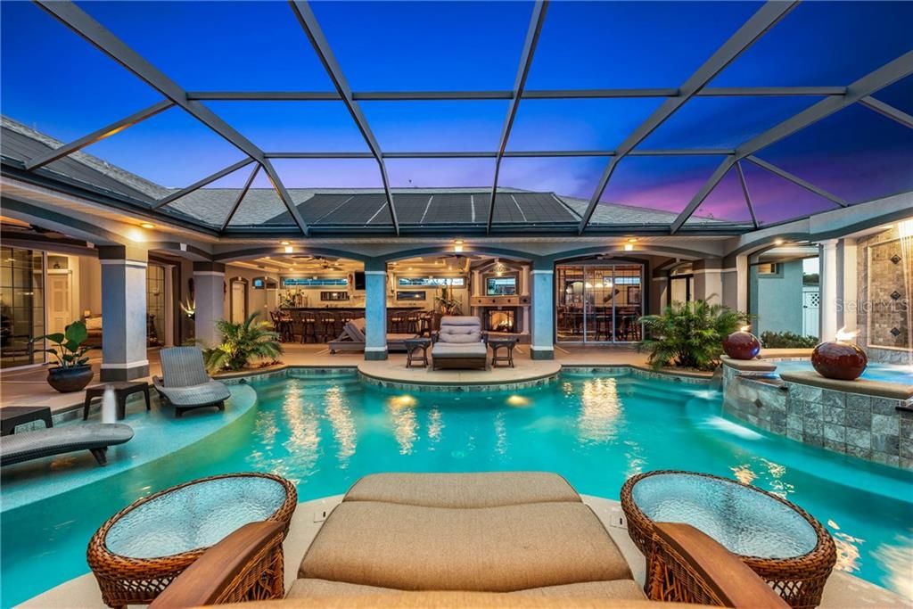 GEORGOUS Tropical Oasis in your own backyard! Solar and Electric heated pool with the waterfall spilling into the gas heated spa.