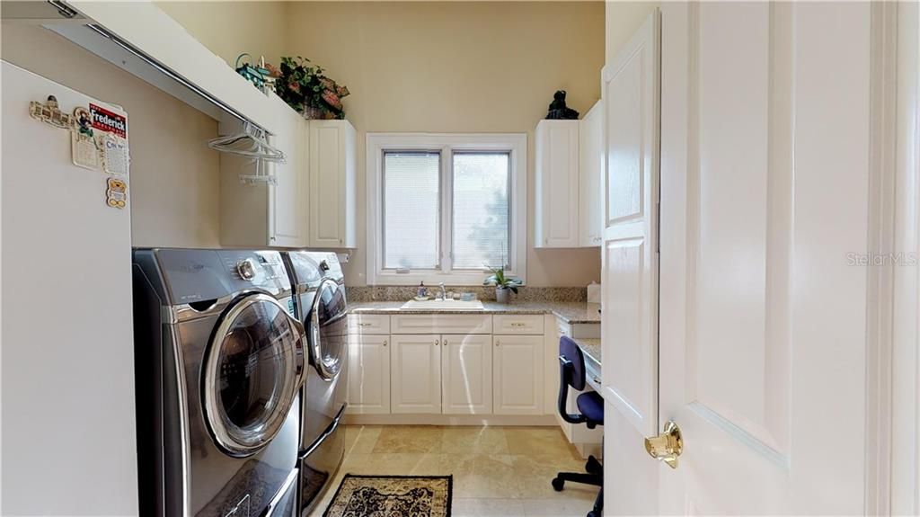 Spacious and bright Laundry Room completed with plenty of counter and storage cabinet space, Built-in ironing Board, and your very own "art/crafts personal desk".  Plus new top of the line Samsung Washer and dryer and "bonus" upright freezer
