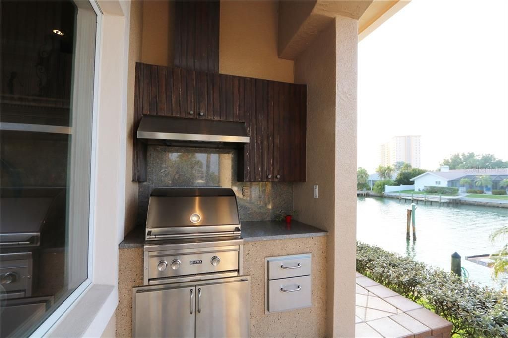 Outdoor cooking area with Built-in Lynx Grill, exhaust fan, granite counter and backsplash, and plenty of storage por your cooking utensils