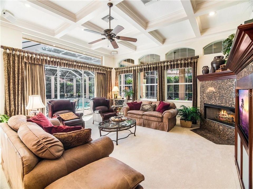 FAMILY ROOM WITH FIREPLACE, OVERLOOKING THE SPARKLING POOL AND LANAI