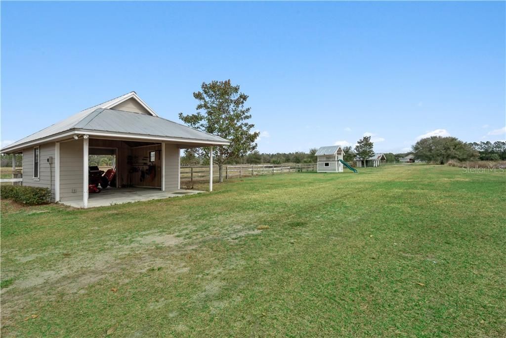 On the way back to the main accessory building is a small WORKSHOP with storage, a playhouse and dog pen