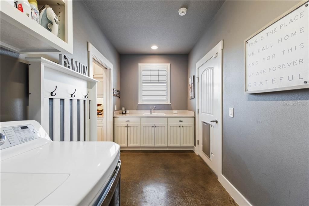 2nd view of mud/laundry room with full sink, counter and cabinetry space!