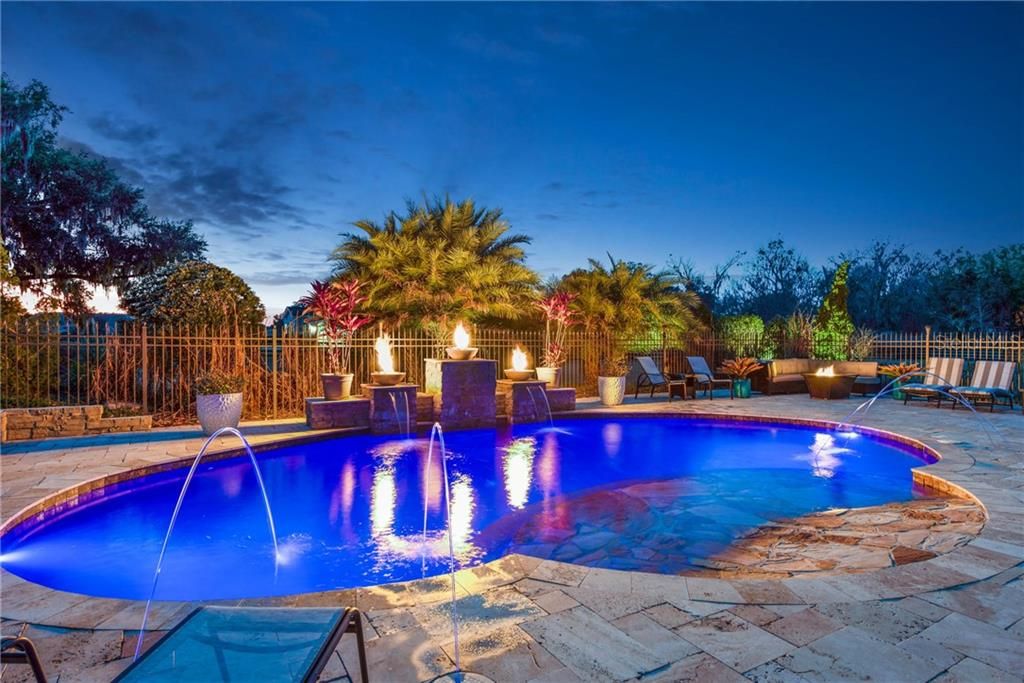 Travertine stone decking, flagstone beach entry pool, 4 water features, 3 water falls, 3 fire bowls, multi-color lighting, pool cleaner sweep.