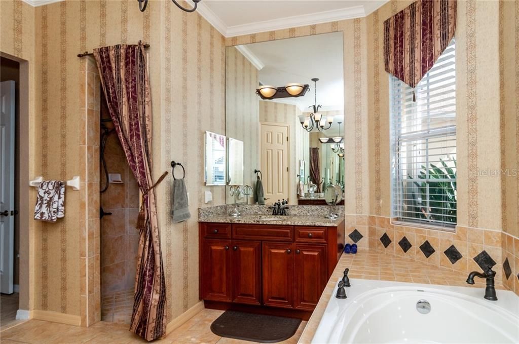 Master bathroom has double vanities a garden tub, a shower stall and a water closet