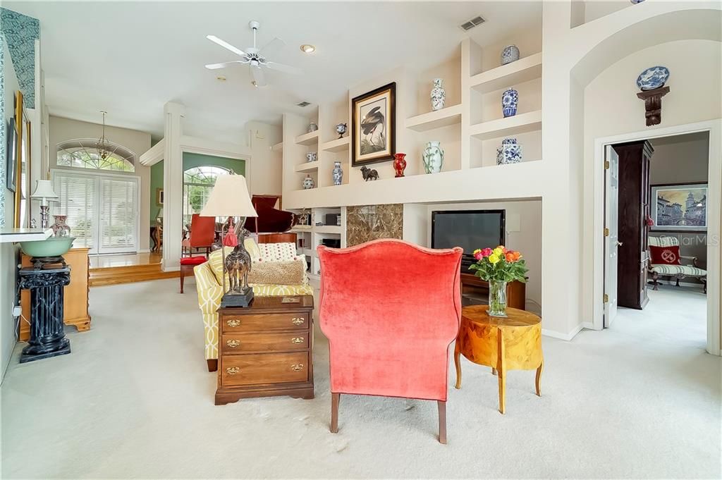 The spacious family room boasts a fireplace, built-in shelving and sliding glass door access to the lanai.