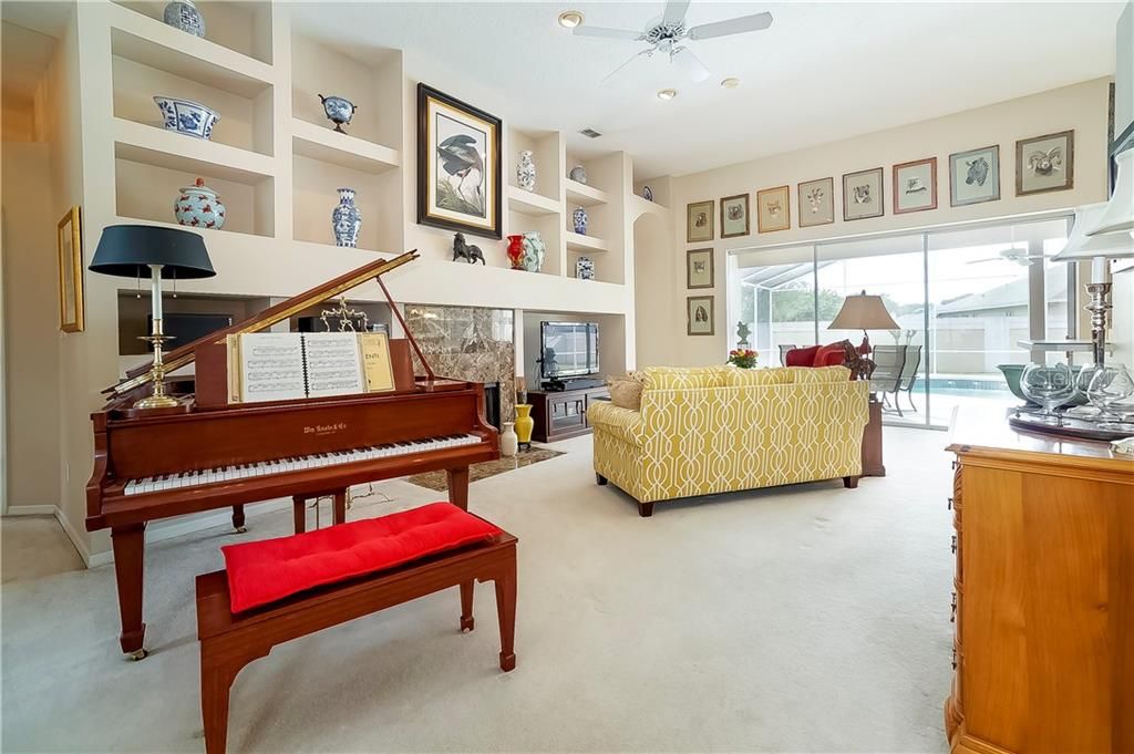 The spacious family room boasts a fireplace, built-in shelving and sliding glass door access to the lanai.