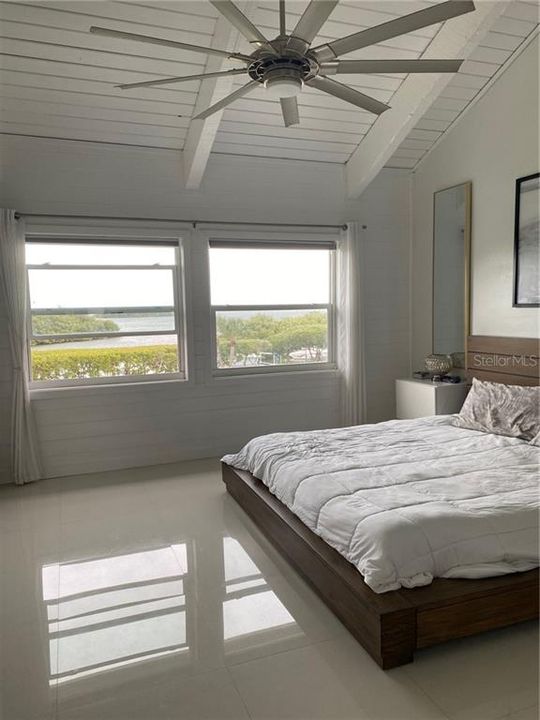 Master bedroom with vaulted ceiling and open water views