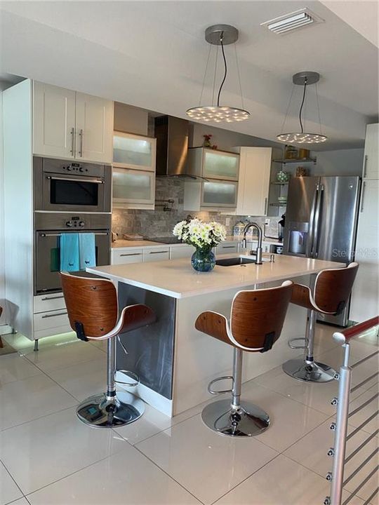 Kitchen with island quartz counters and undercounted lights