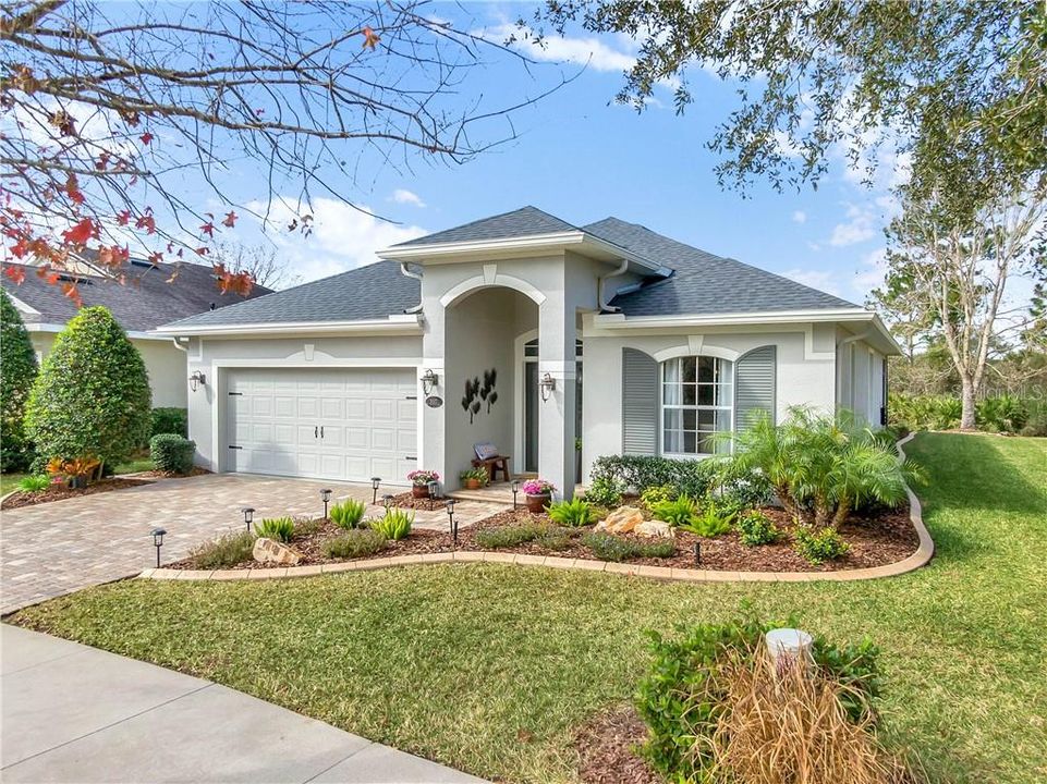 Exterior front of home w/ paver driveway & landscape bed concrete border