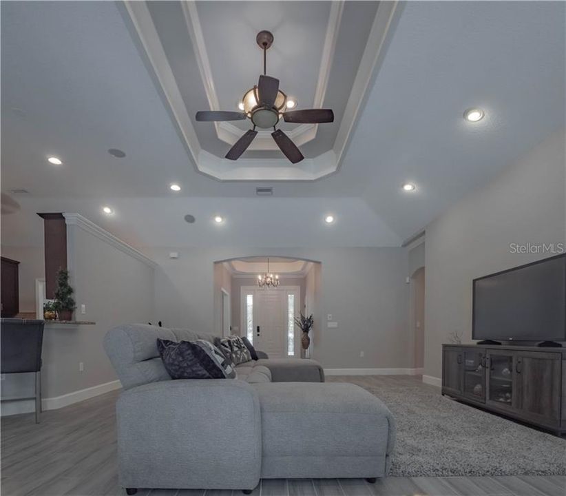 Living Room view from the pool doors looking toward the front door. Ceiling has custom wood trim.