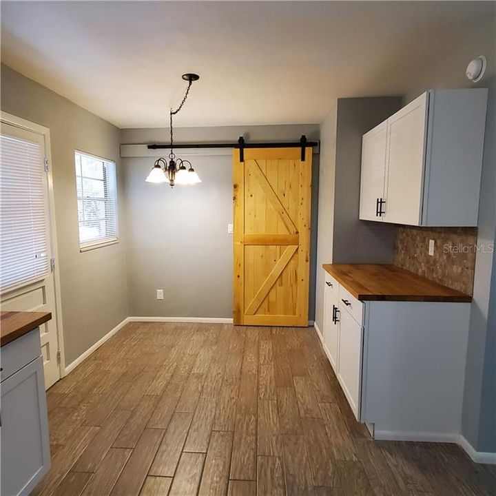 Dining area with barn door to inside utility room