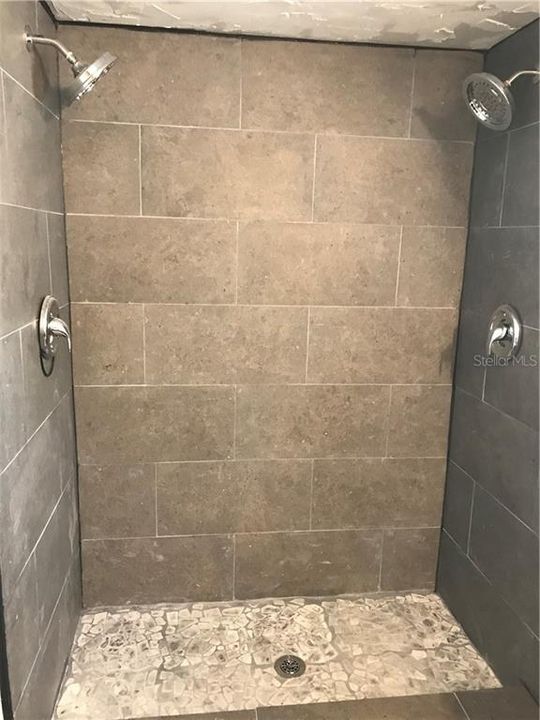 Newly renovated primary shower with double shower heads.