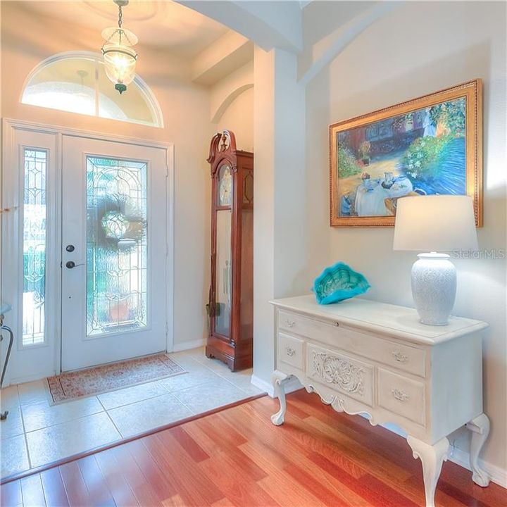 Beveled glass front door & sidelight welcome you into the foyer with vintage light, art niches & wood floors.