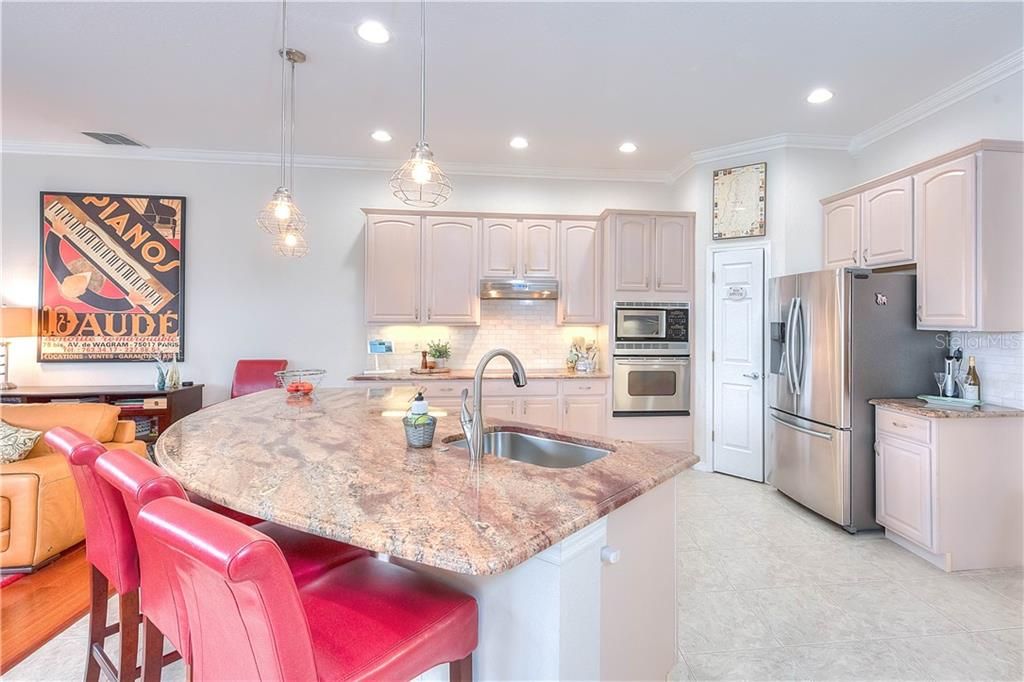 The large, updated kitchen features built-in range & microwave, Bosch cooktop & dishwasher, new French style refrigerator, island, walk-in pantry & acres of granite!