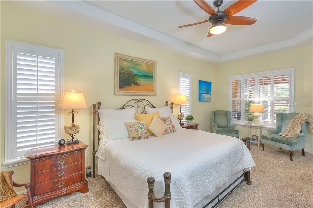 King-size Master bedroom features Plantation Shutters, Coved ceiling, upgraded ceiling fan, sitting area & 2 walk-in closets!