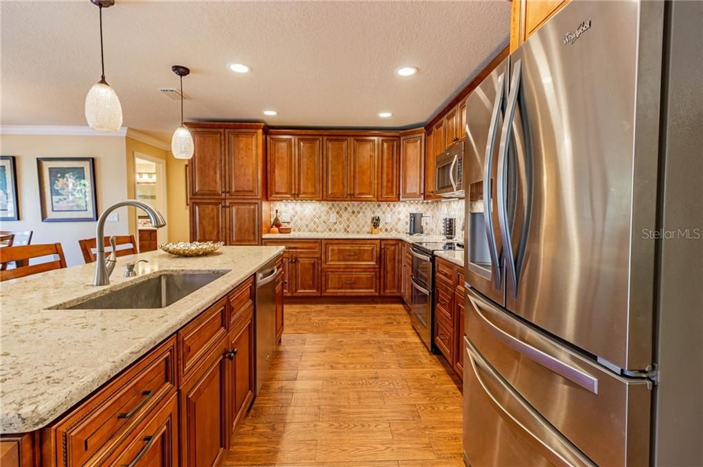 Gourmet kitchen includes beautiful cabinetry,quartz counters and tile backsplash