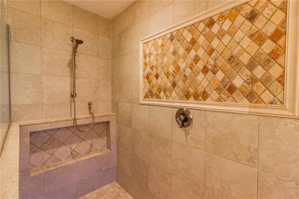 Master oversized shower with built shelf and tile design