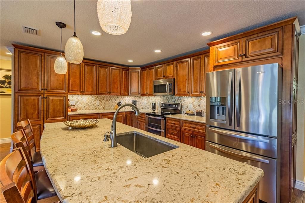 Huge kitchen island and stainless steel appliances