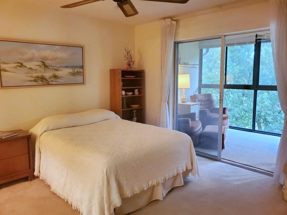 Spacious bedroom with sliding doors to enclosed lanai with private nature view