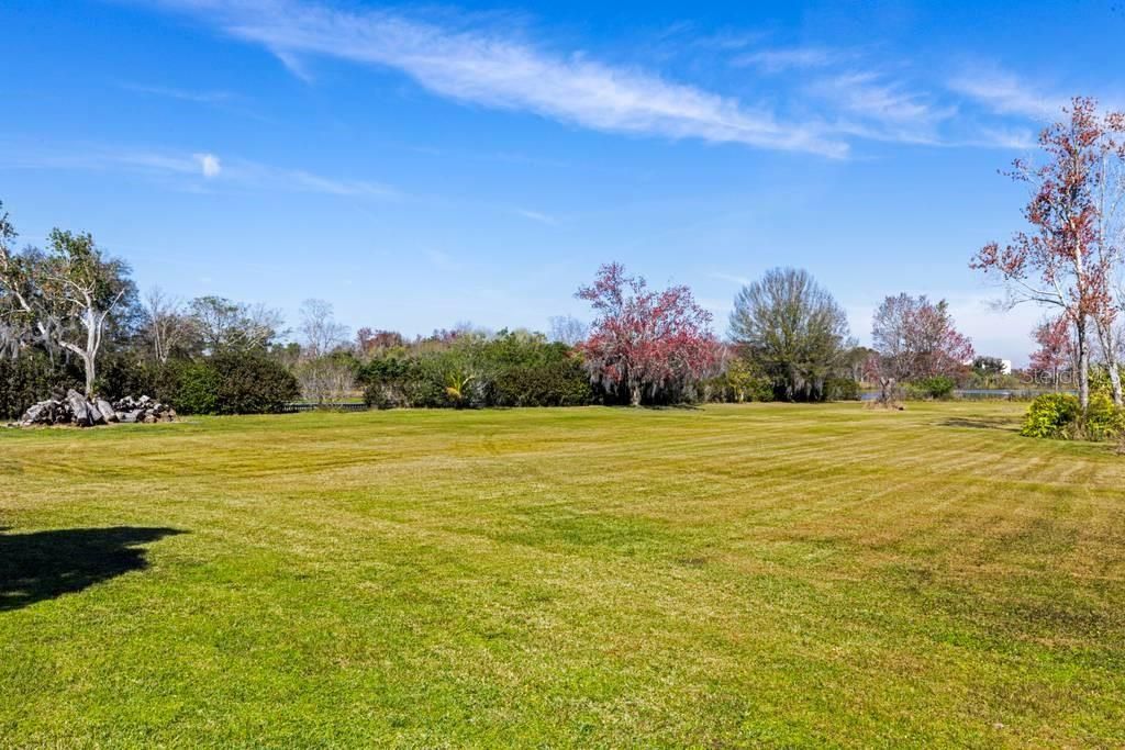 Looking West in the backyard over to canal; Lake May to the right.