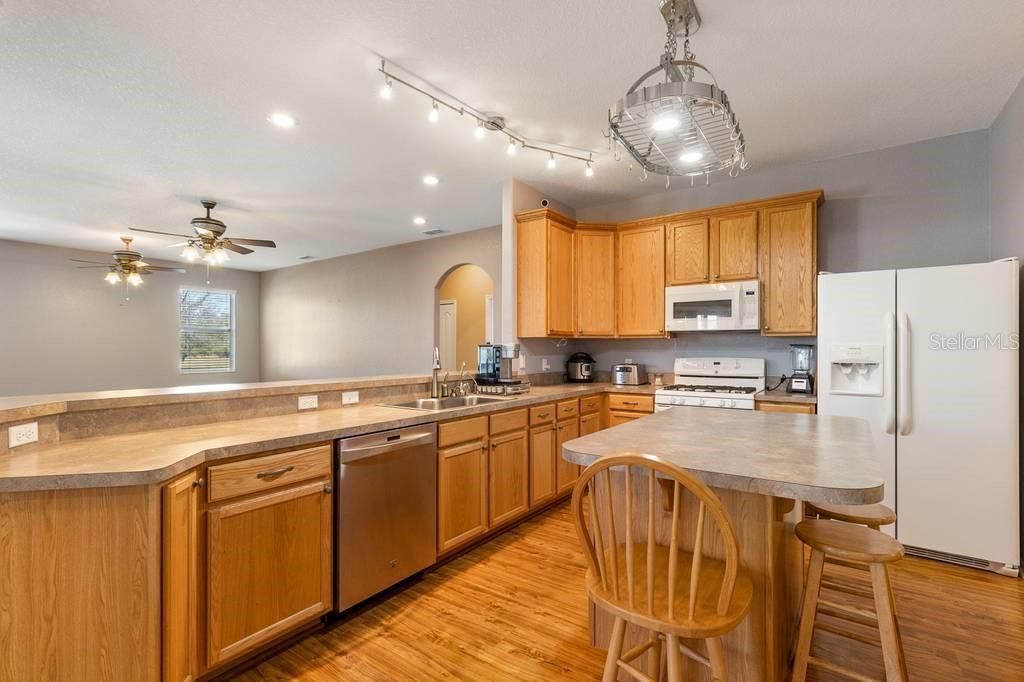 Kitchen Open to Family Room; windows look out to backyard and lake beyond.