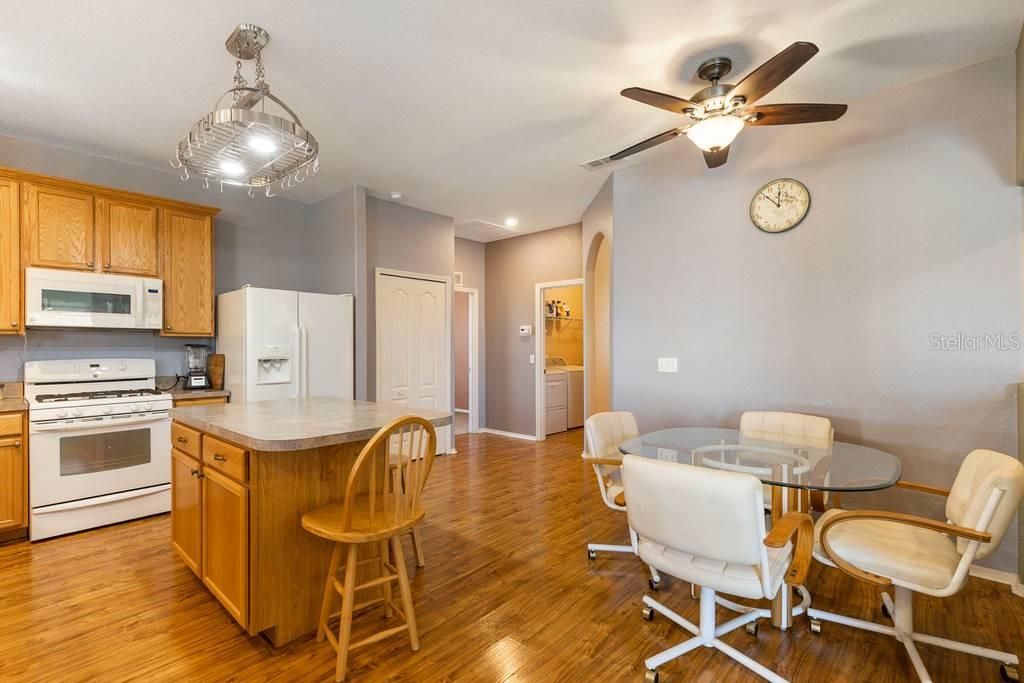 Eat in nook in kitchen and island with breakfast bar - provide plenty of space for casual dining.  Doorway to left leads to Bedroom 2 with an ensuite full bath, center door leads to laundry room and beyond to garage, and arched doorway leads to Dining Room